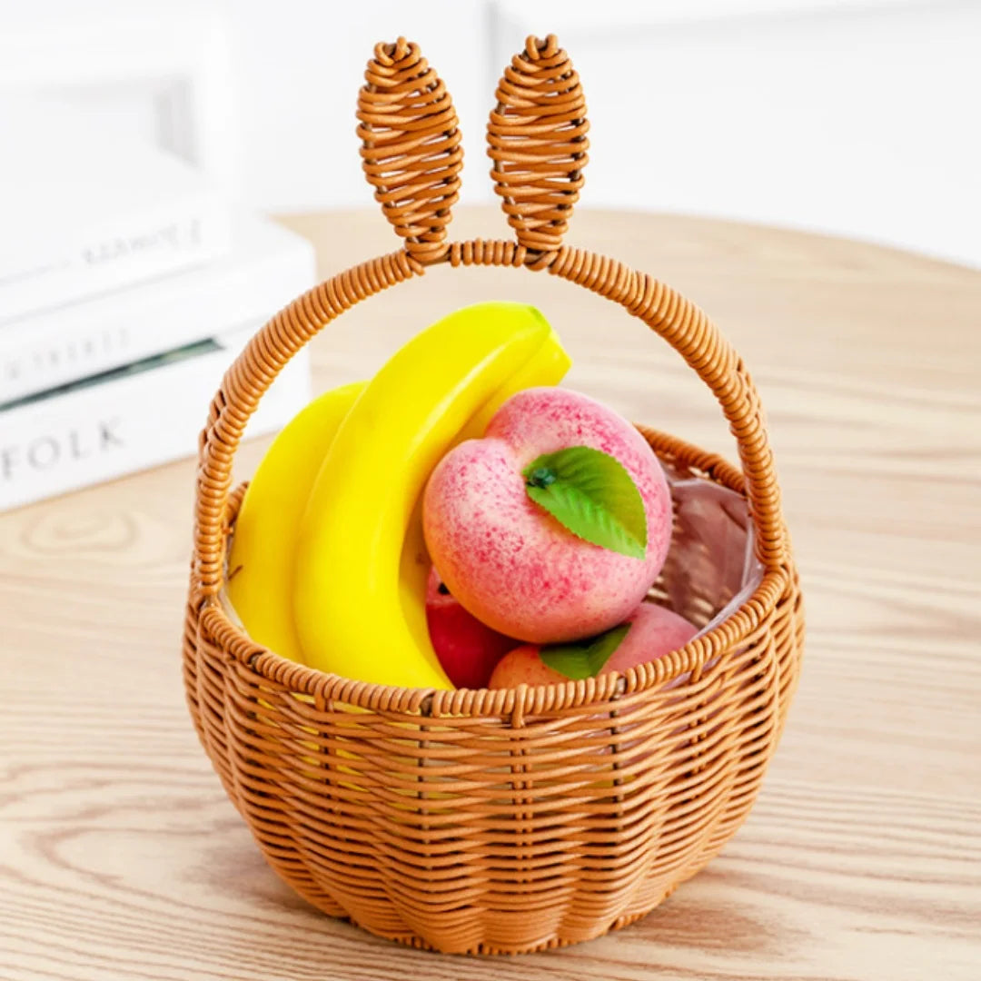 Brown bunny ear basket filled with artificial fruit on a table