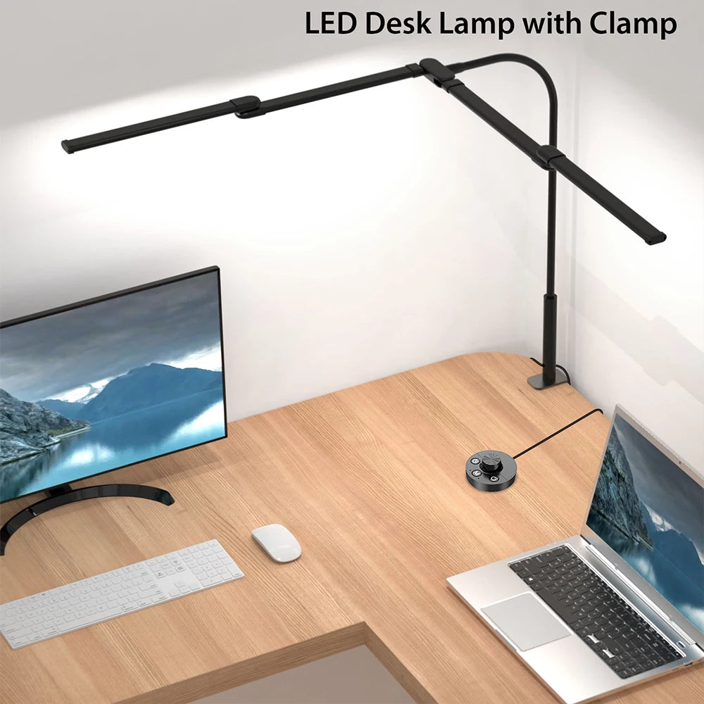 Overhead view of wide LED desk lamp clamped to corner of large desk with monitors and laptop