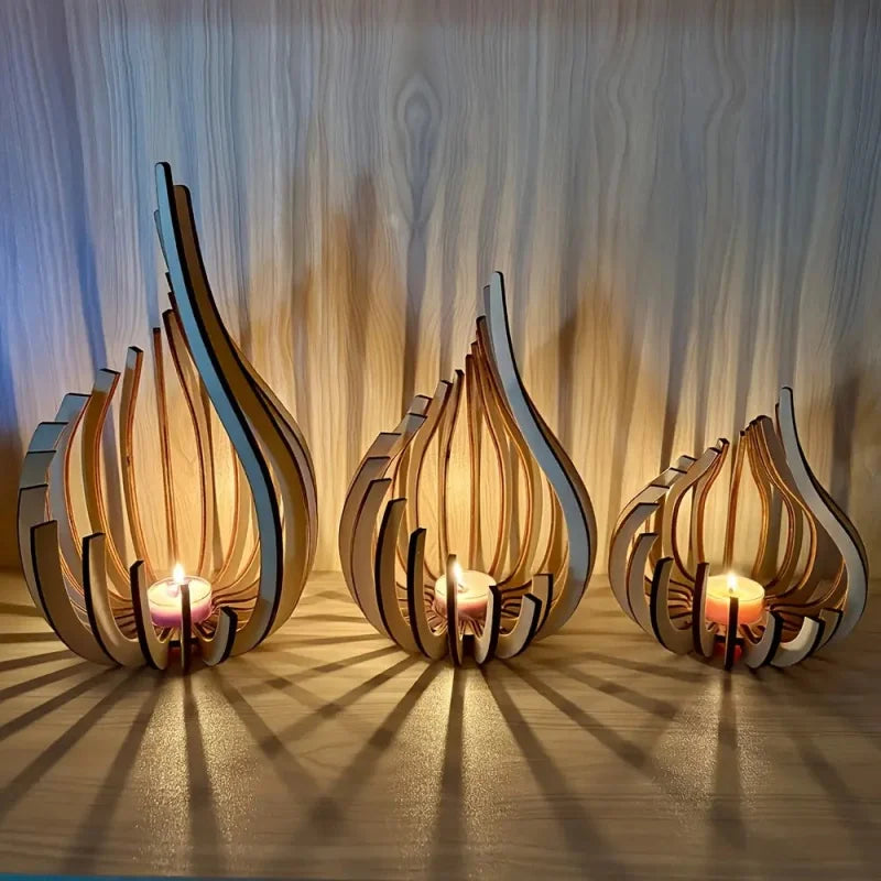 Three handmade wooden flame-shaped candle holders with lit tealights on a shelf, casting decorative shadows