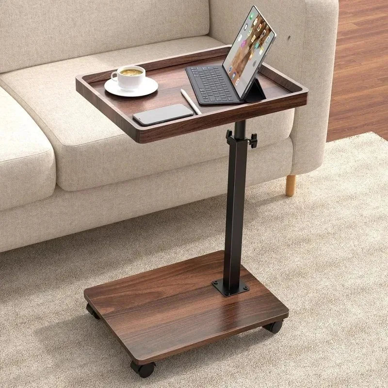 Rectangular modern rolling side table with storage shelf holding laptop and coffee beside a sofa