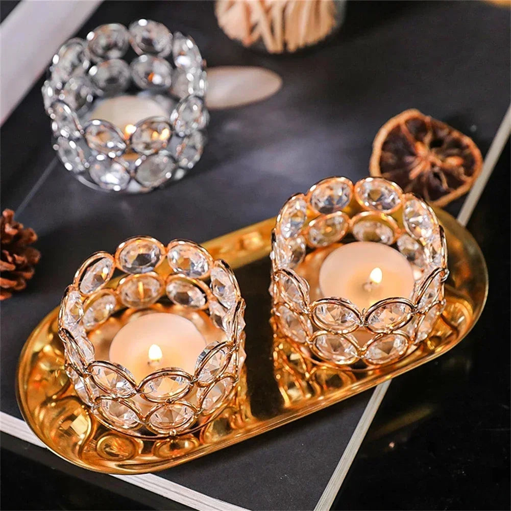 Two gold and one silver crystal tealight holders on a decorative tray, holding tealight candles