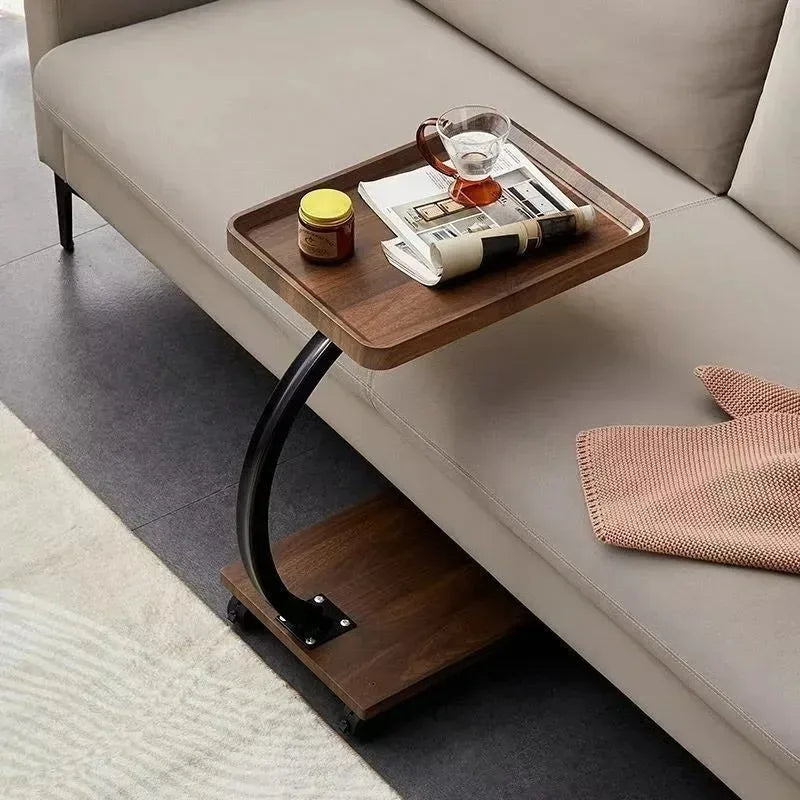 Rectangular rolling side table with tea and newspaper beside a neutral sofa