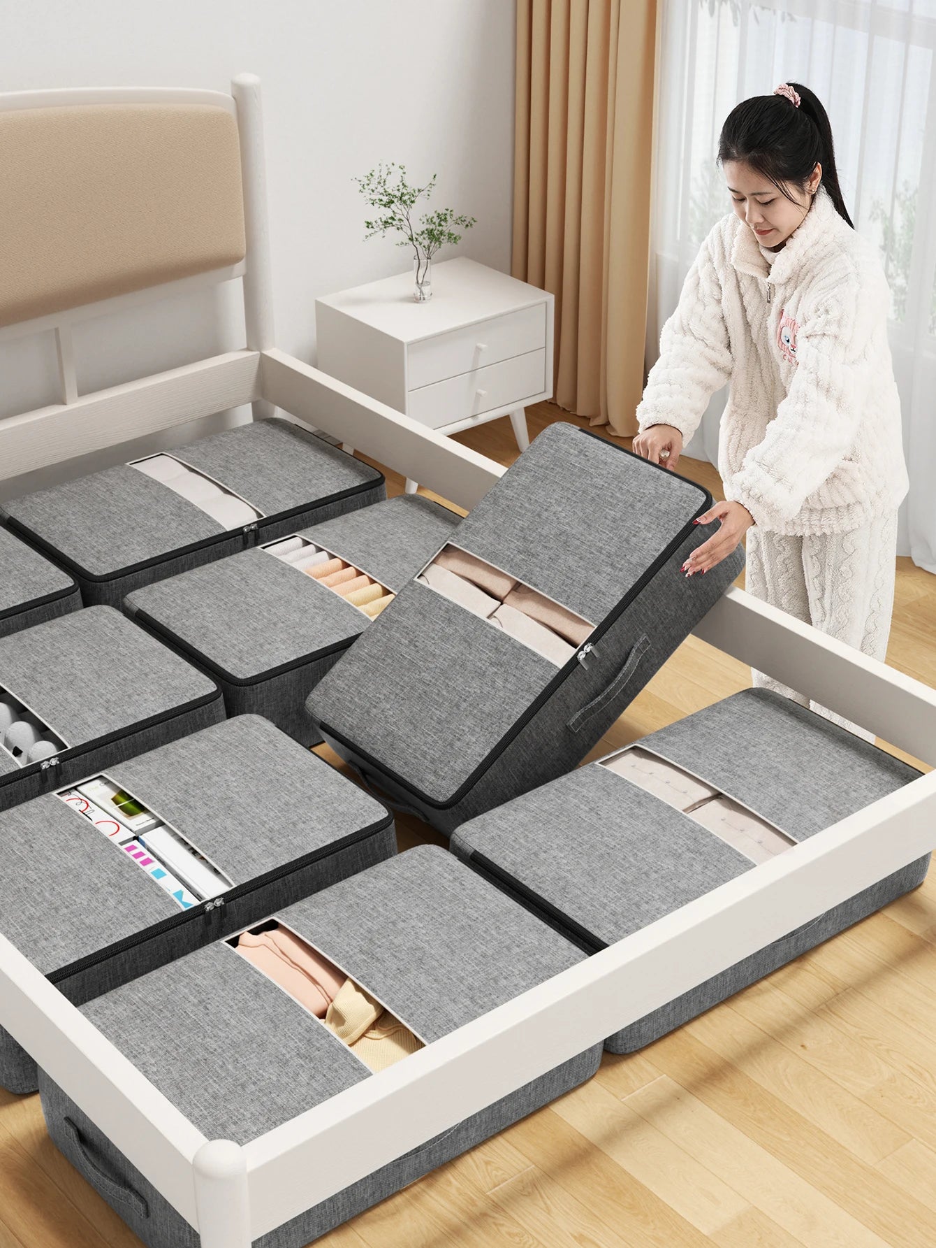 Multiple grey underbed storage bags arranged beneath a bed frame in a tidy bedroom