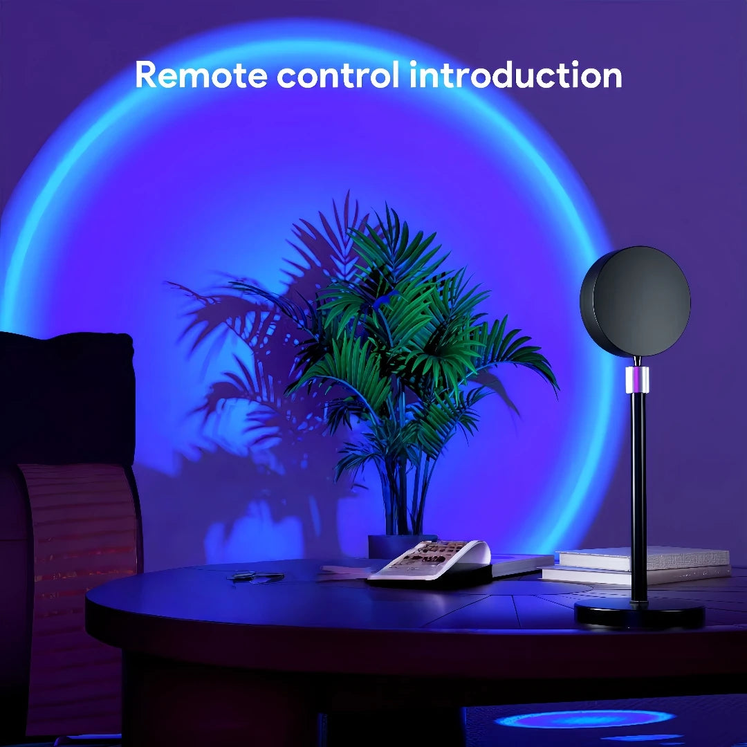 Sunset projection lamp casting blue light on a wall with a plant and books, remote on table