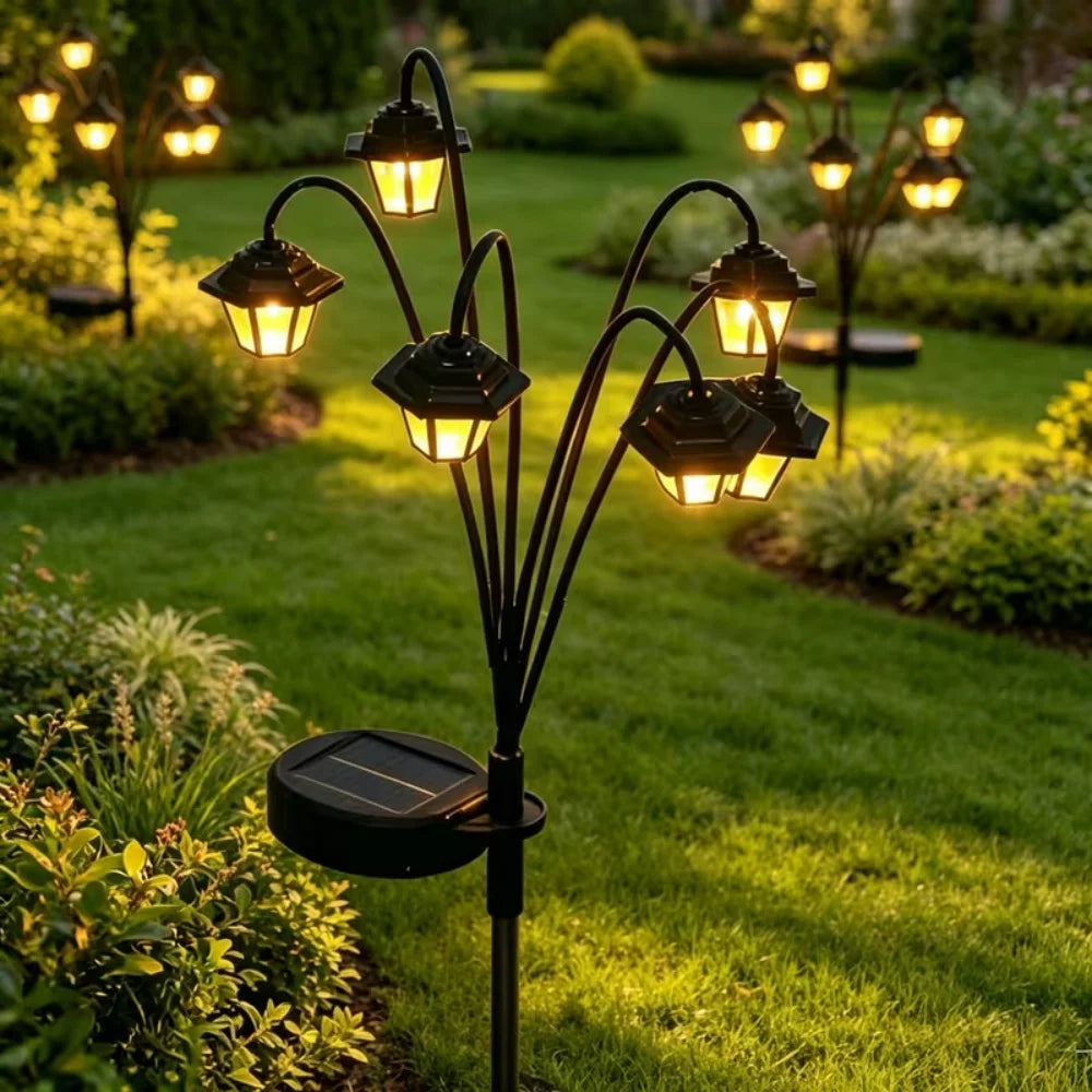 Solar lantern stake light with 6 warm LED heads illuminating a grassy garden pathway