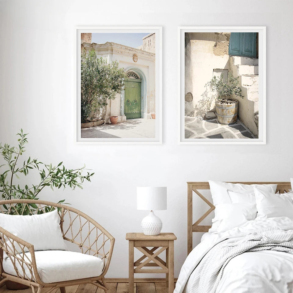 Pair of Spanish-themed canvas prints with greenery framed above a bed in a bedroom setting