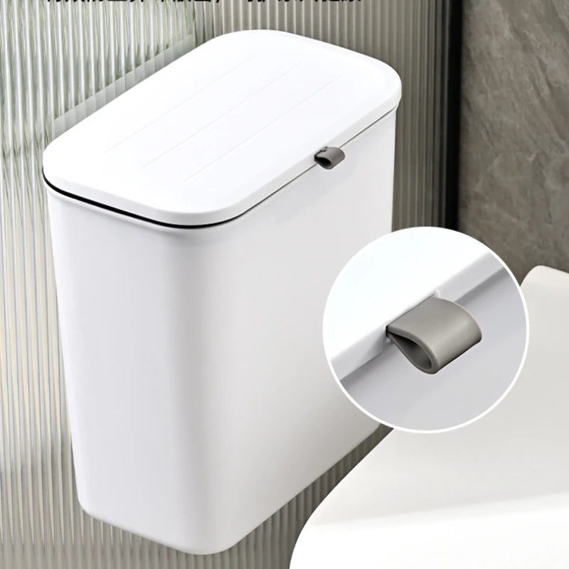 closeup of wall-mounted trash bin in white with lid and hanging detail