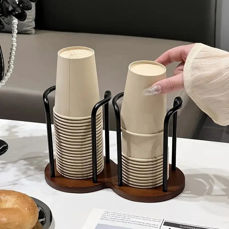 Hand reaching for a cup from a bamboo and wood cup holder rack