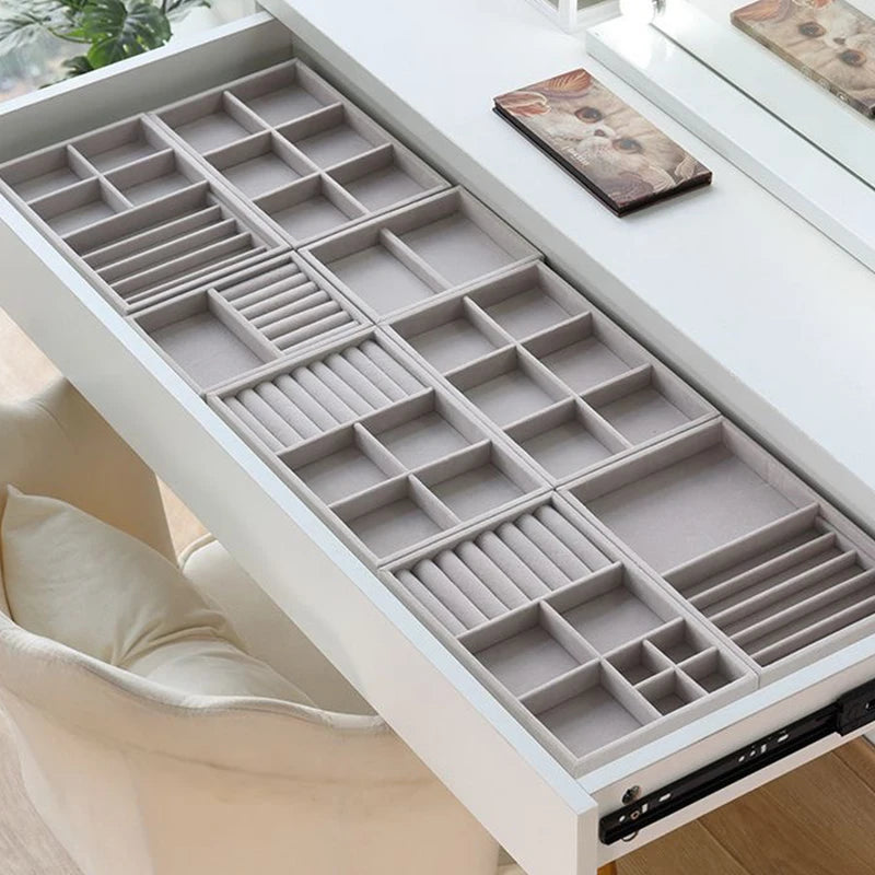 Top view of a vanity drawer filled with various velvet jewelry trays neatly separating accessories