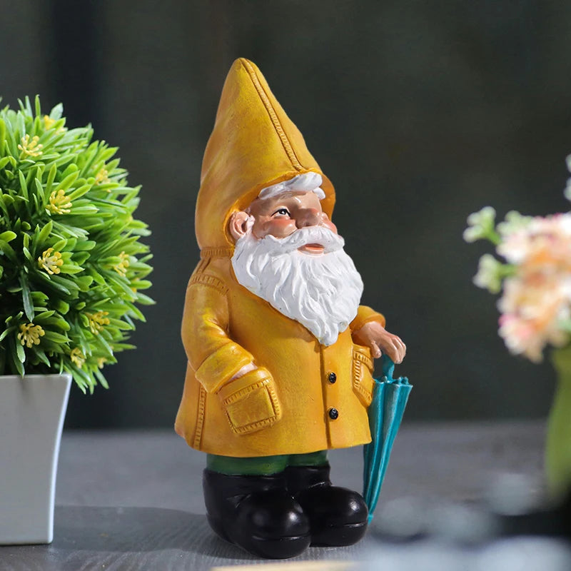 Garden gnome statue with yellow raincoat and umbrella, front right view, on tabletop