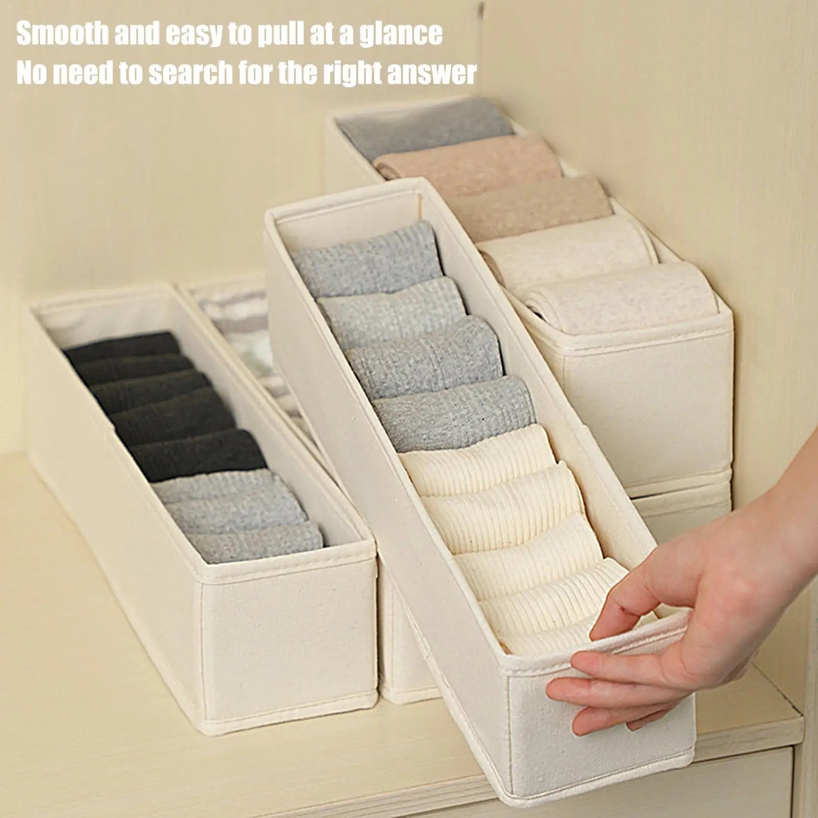 Hand pulling a slim fabric drawer organizer filled with socks for easy access in a dresser or closet