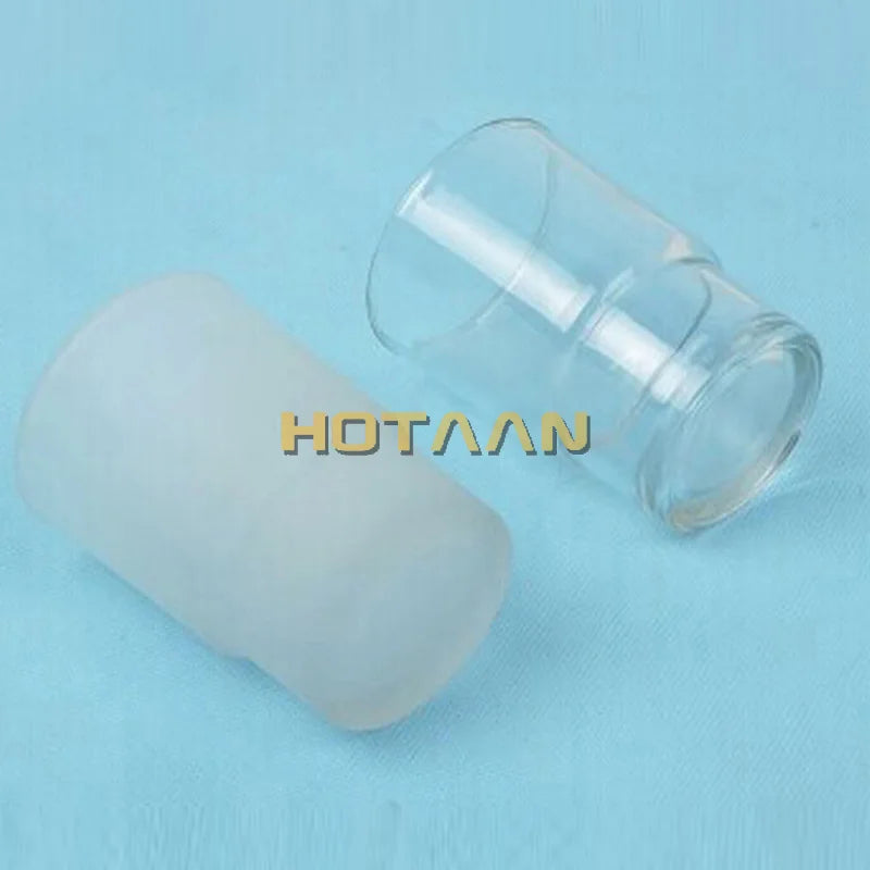 Transparent and matte glass cups laid on side on blue background