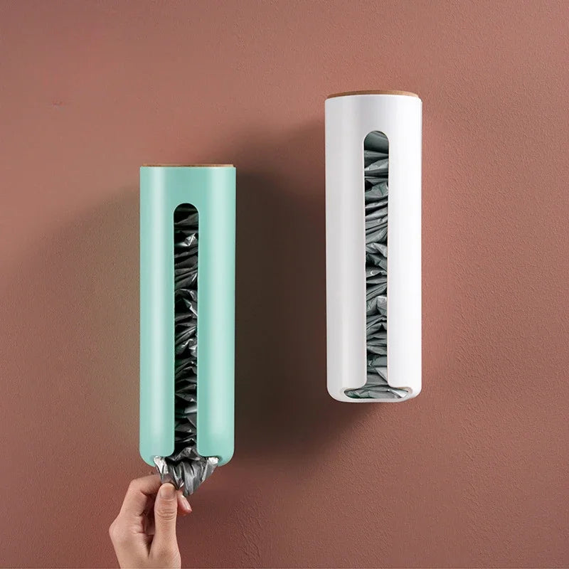 Two wall-mounted plastic bag dispensers in green and white on a pink wall