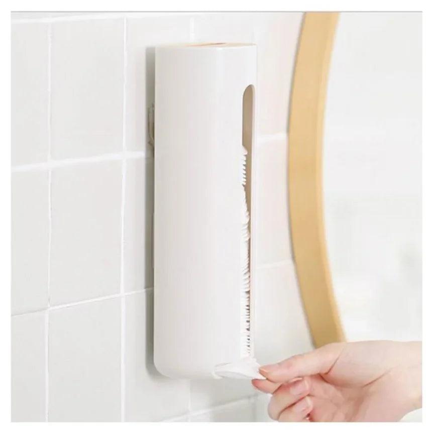 Person dispensing a cotton pad from a wall-mounted white cotton pad holder next to a mirror