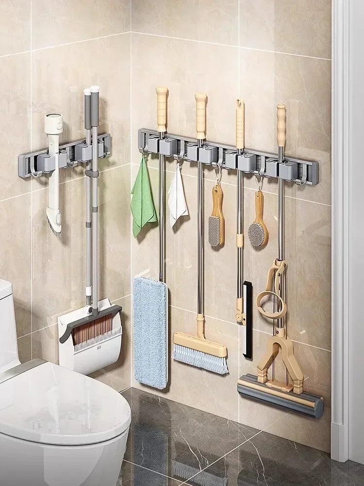 Bathroom with two wall-mounted mop and broom racks holding assorted cleaning tools