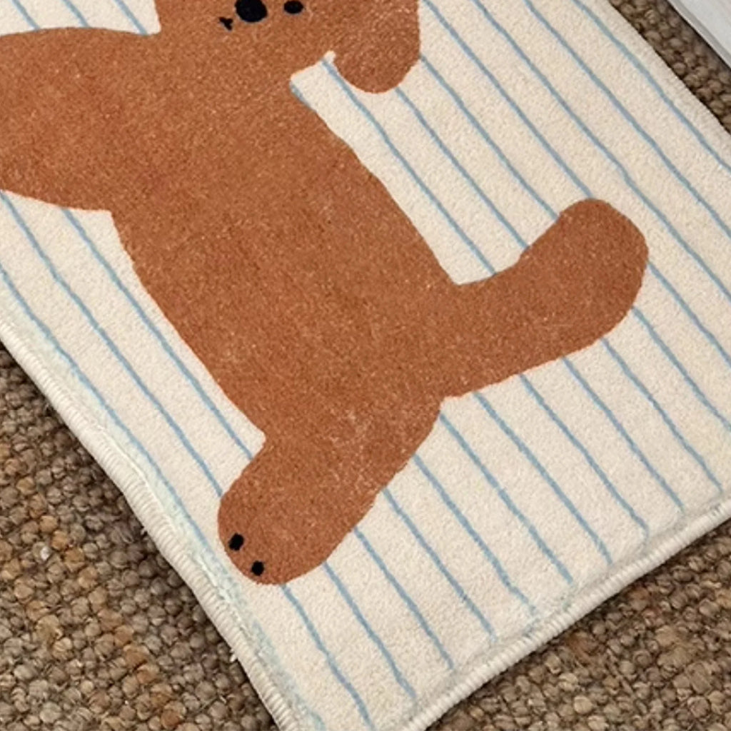 Detail view of cartoon puppy door mat on a textured floor