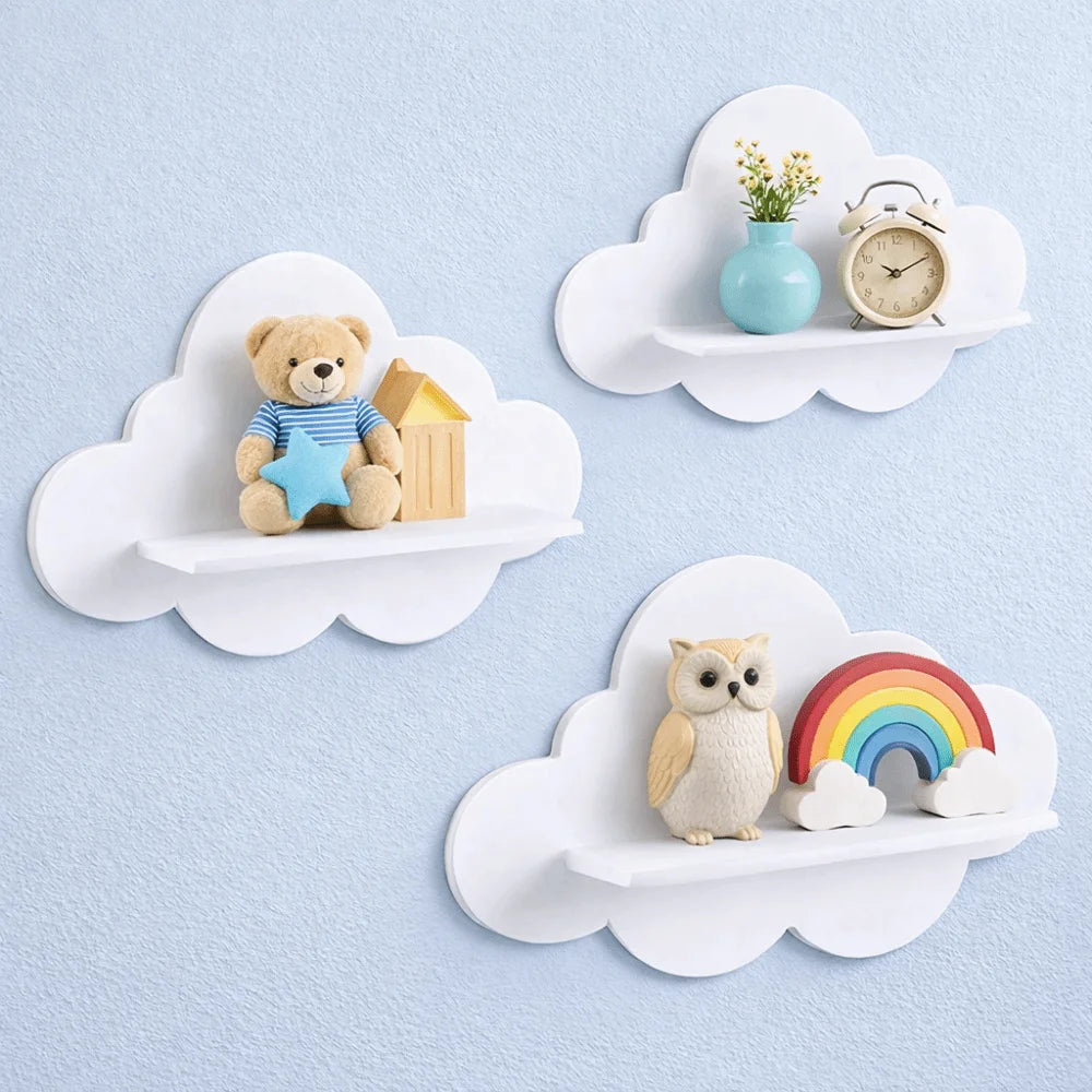 Three white cloud wall shelves on a pale blue wall, styled with toys and decor