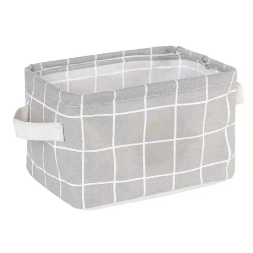 Collapsible fabric storage basket in light grey with white grid pattern and side handles, empty.