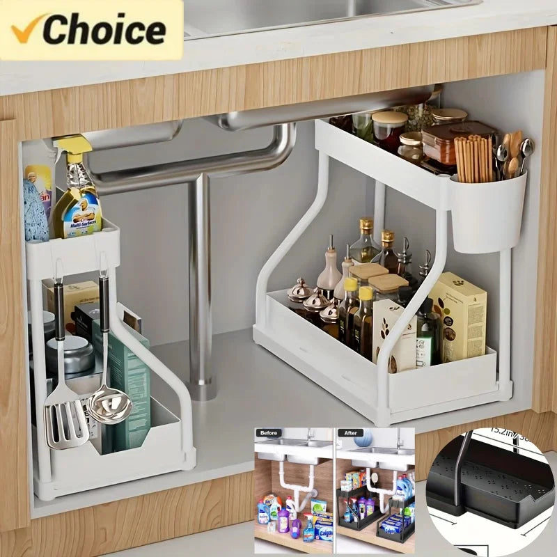 White two-tier pull-out under sink organizers neatly storing bottles, utensils, and cleaning supplies in a wood kitchen cabinet