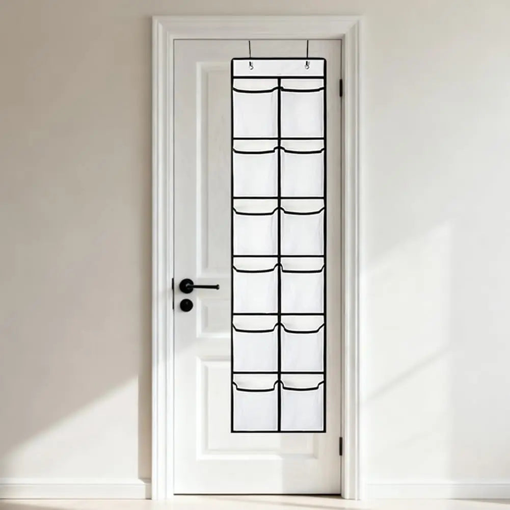 white mesh hanging shoe organizer with 12 pockets on a closed white door in a hallway
