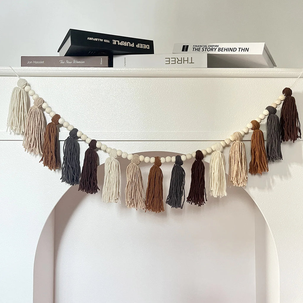 beaded tassel garland hanging on a white shelf in a modern bedroom