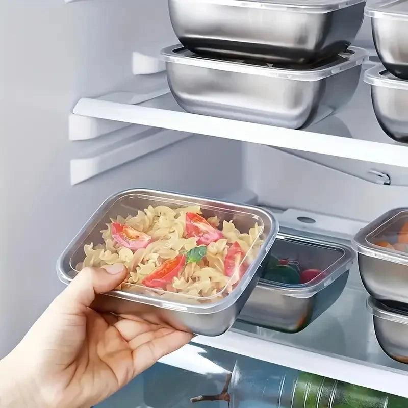 hand placing a stainless steel container with pasta into a refrigerator, other containers are visible