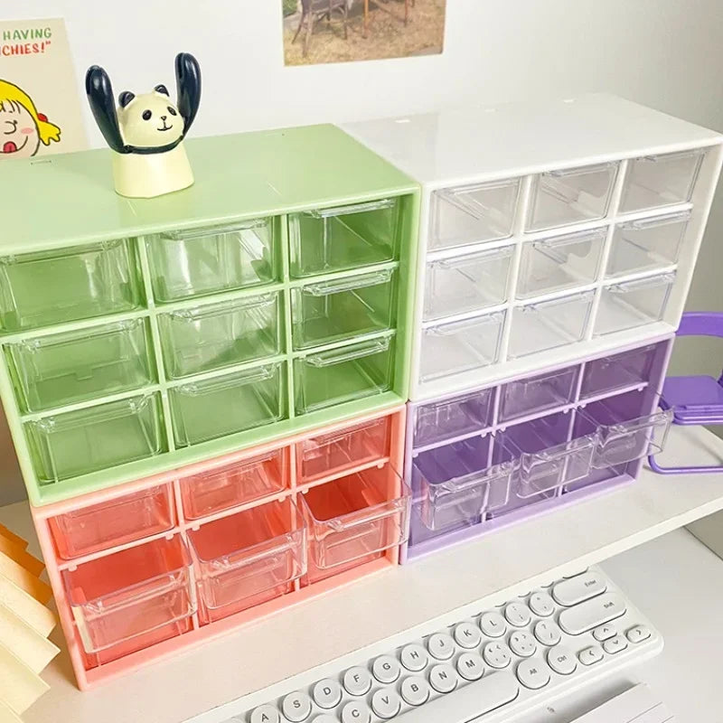 Green, pink, white, and purple desktop organizer boxes with open clear drawers