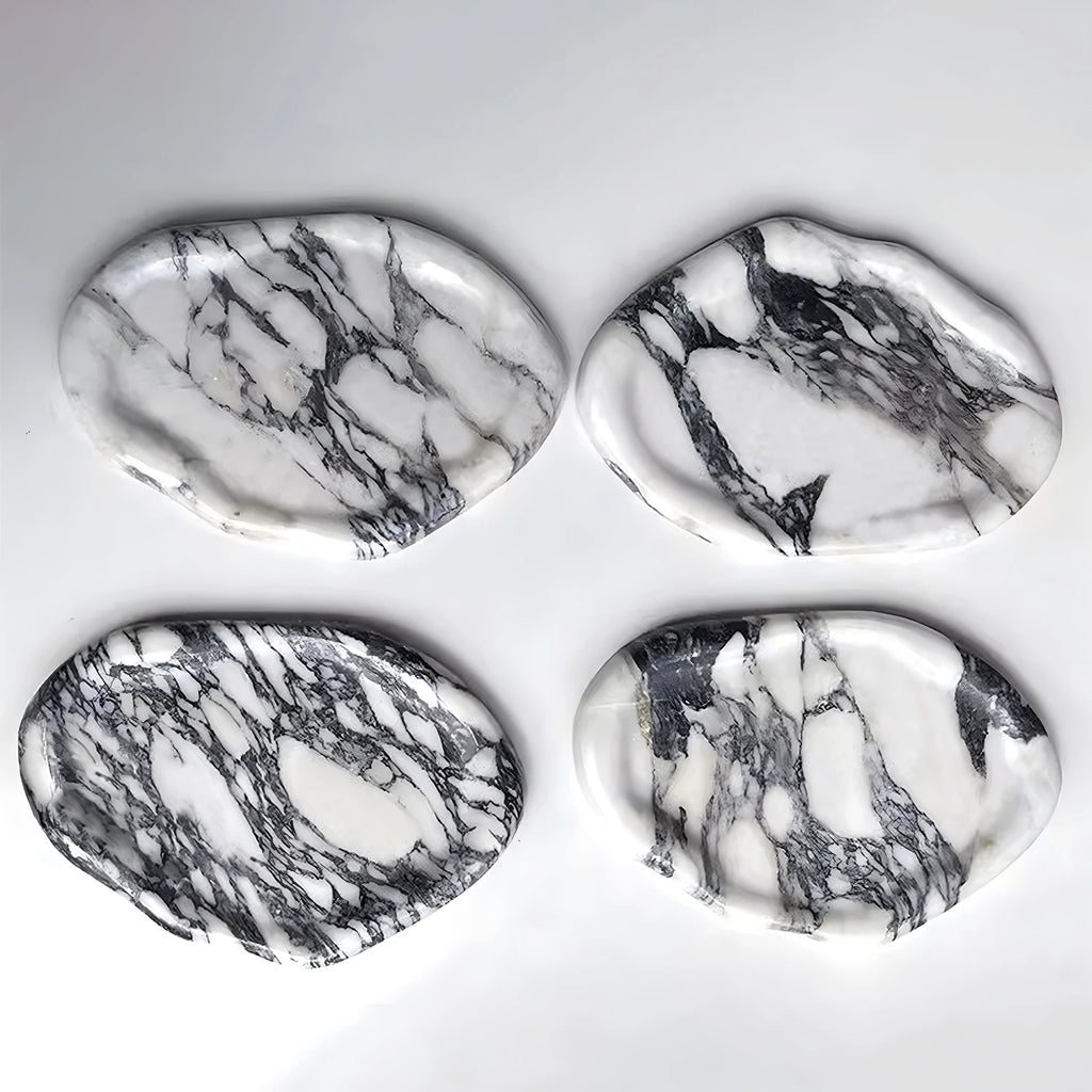 Four marble-pattern irregular ceramic trays displayed on a white background
