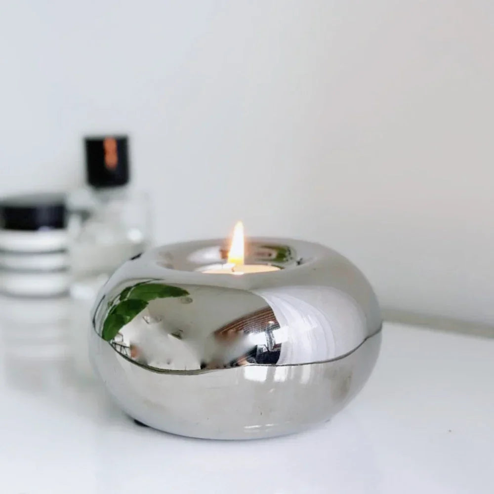 modern round silver ceramic tealight holder with tealight candle on a desk