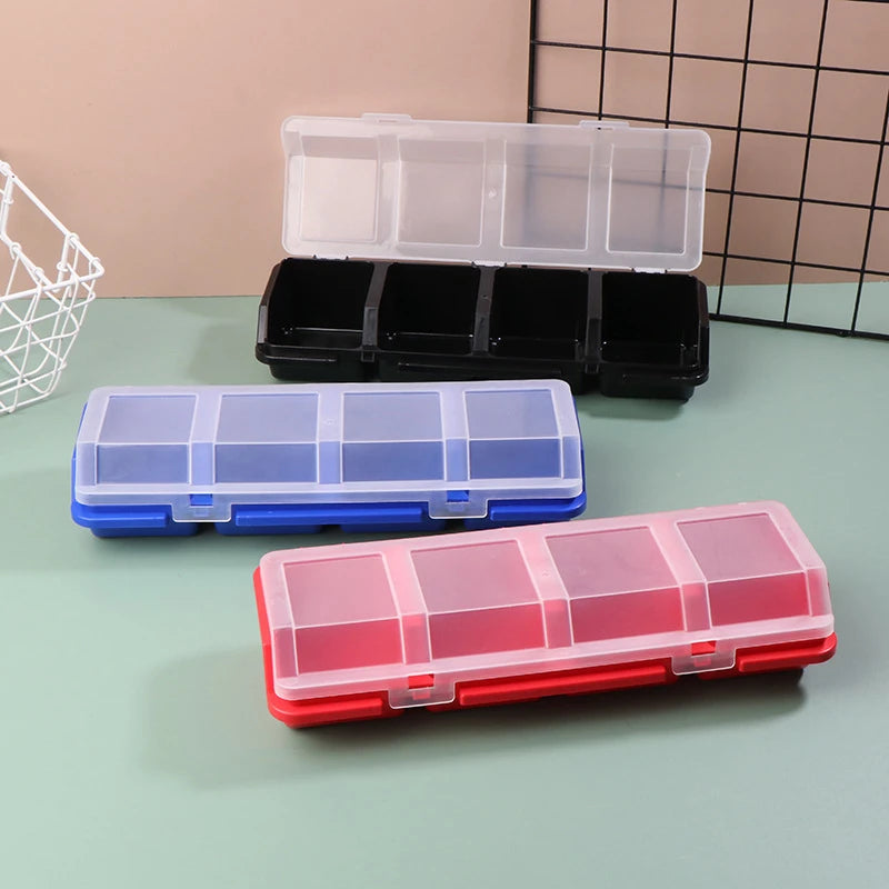 Plastic organizer boxes in black, blue, and red with transparent lids, shown on a tabletop