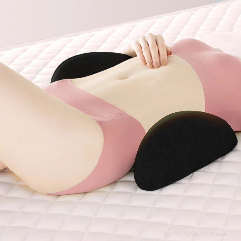 Person lying on bed using two black contoured lumbar support pillows