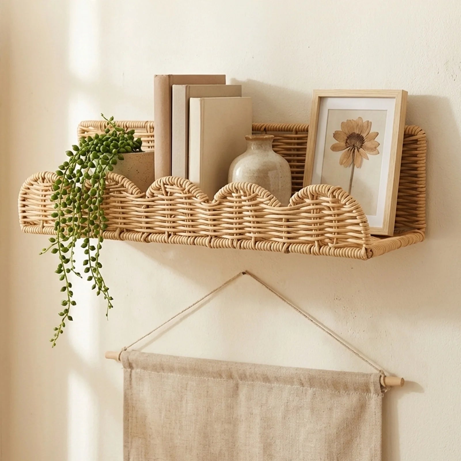 Fan-shaped woven wall shelf displaying books, pottery, a picture frame, and a trailing plant in a living room or bedroom