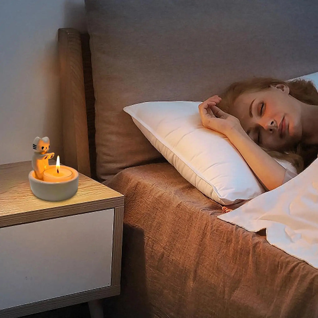 cat tealight holder on bedroom nightstand beside sleeping person