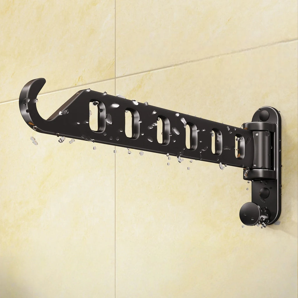 Matte black foldable drying rack with water drops on a tiled bathroom wall