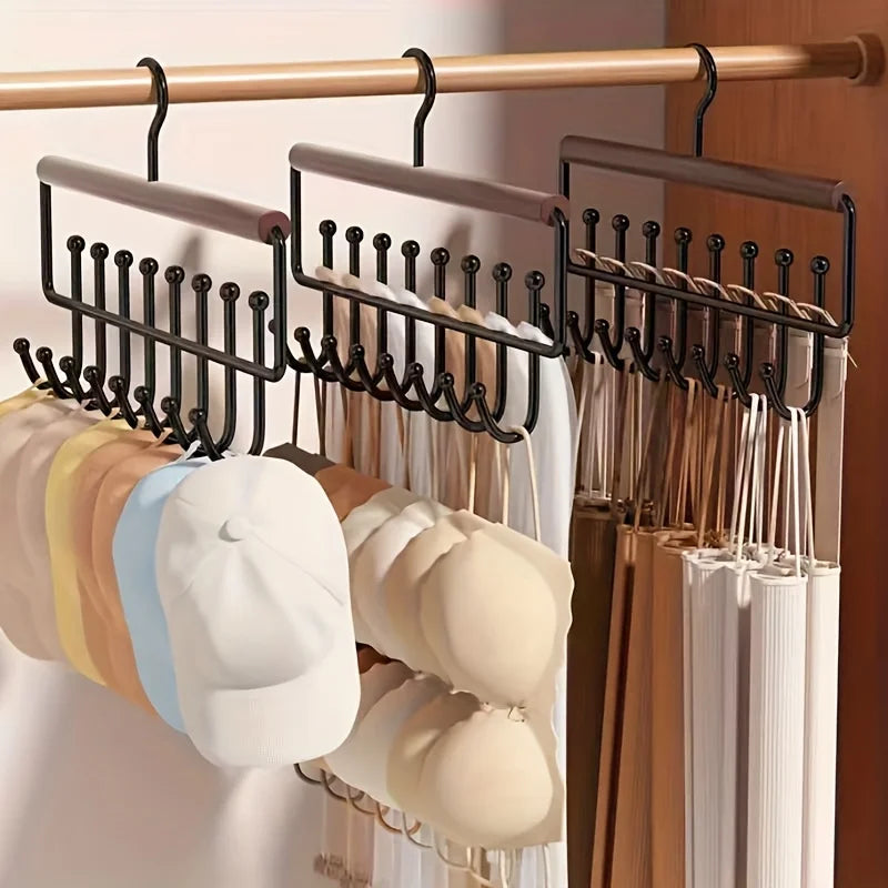 Three metal multi-hook hangers in a closet holding hats and bras