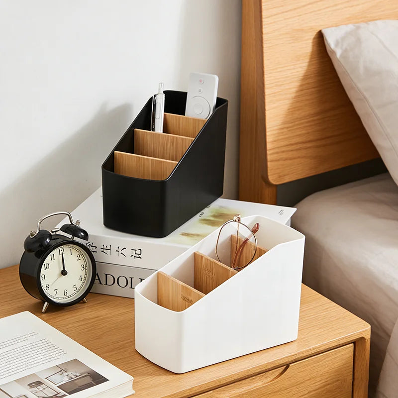 Two 4-compartment remote organizers in black and white on bedside tables, storing remotes, glasses, and pens