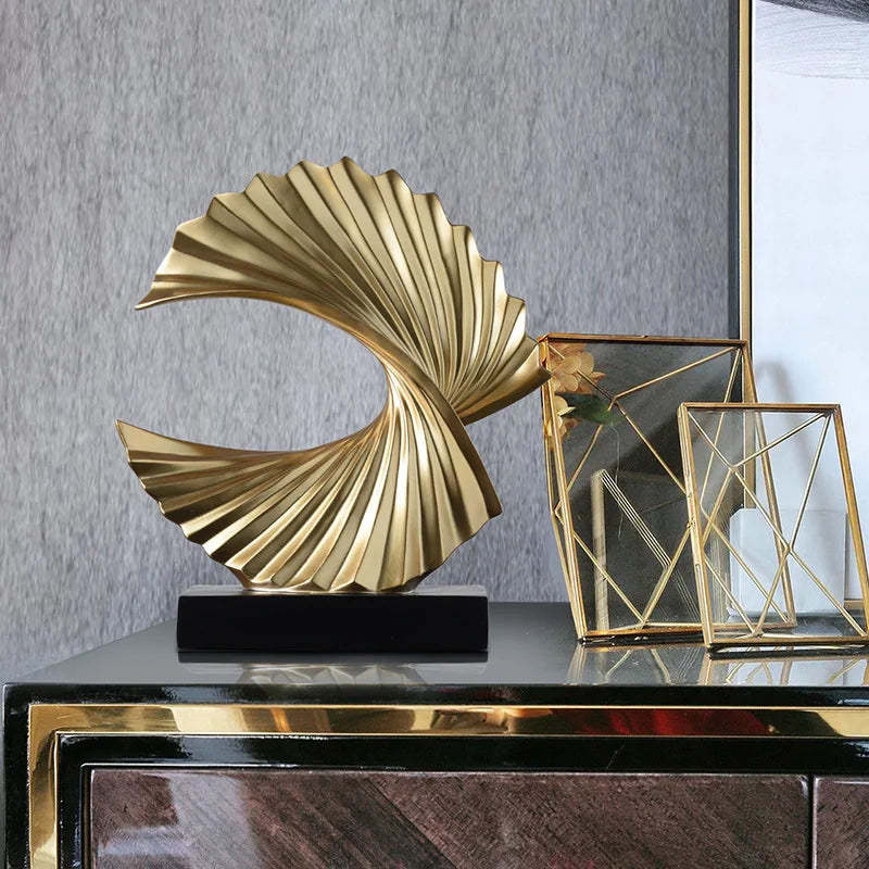 gold art deco wave sculpture on cabinet with geometric gold photo frames
