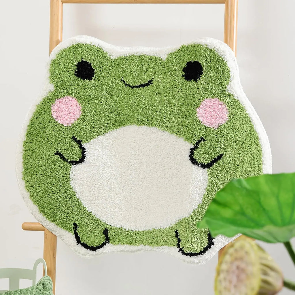 Green cute frog bath mat displayed on a wooden ladder, highlighting playful design and knotted texture