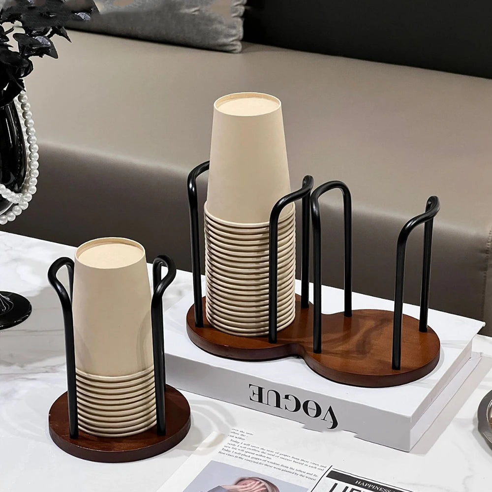 Two bamboo and wood cup holder racks with disposable cups displayed on a living room table