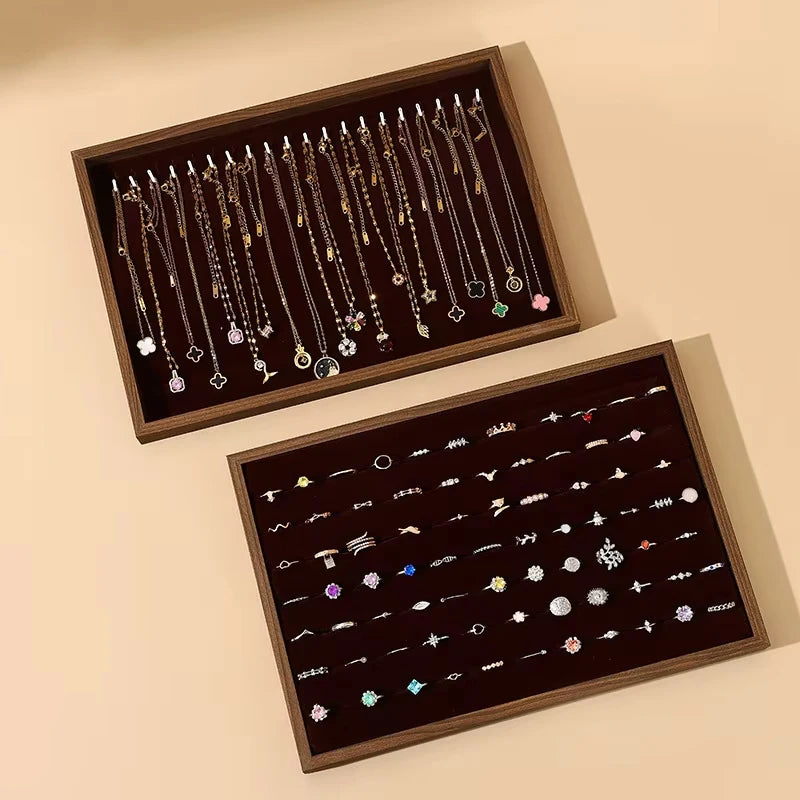 Two wooden jewelry trays, one for necklaces and one for rings, arranged for easy access