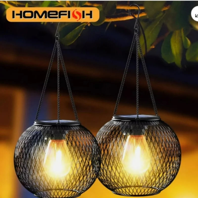 two round black mesh solar lanterns hanging from tree branches at dusk
