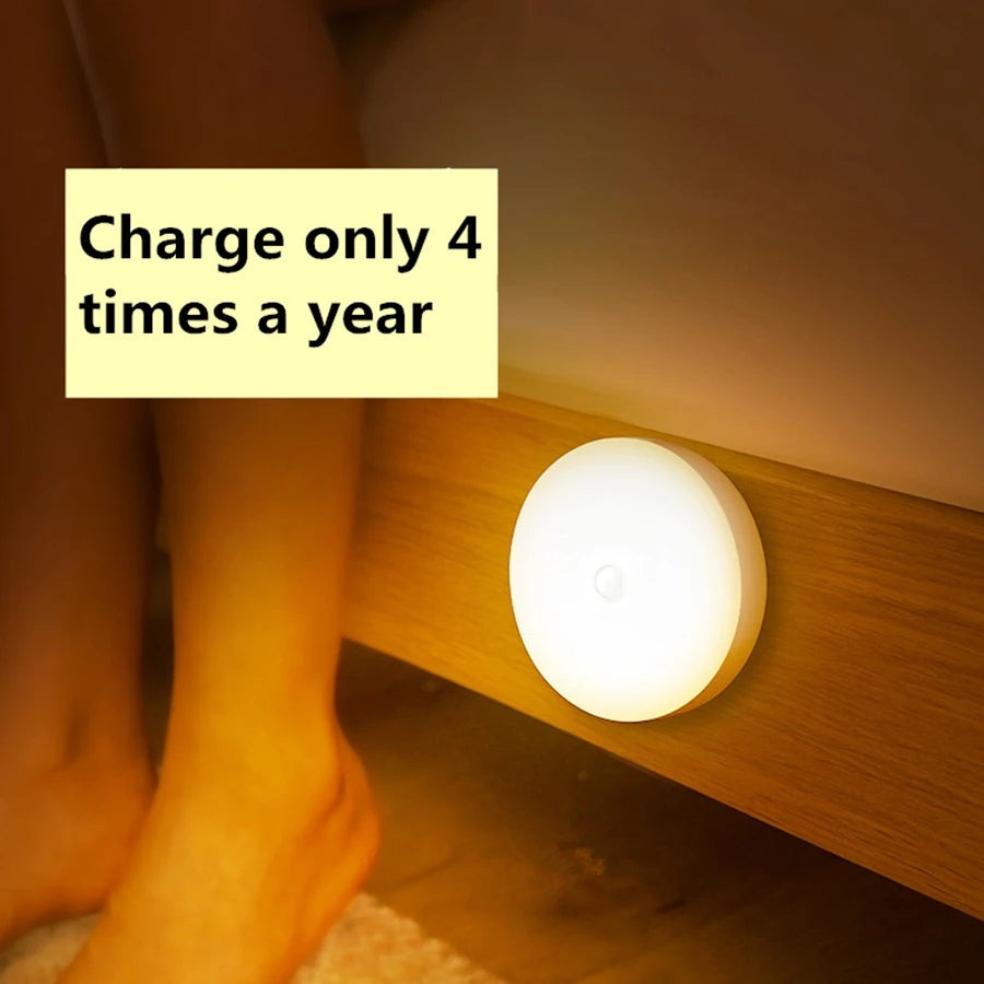 Magnetic motion sensor night light glowing on a bedside frame, feet visible nearby