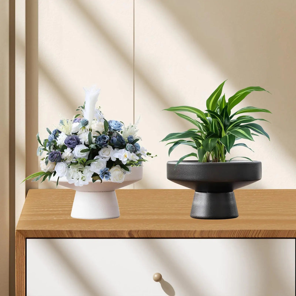 Flowerpot vases styled on dresser: white with floral arrangement, black with leafy plant