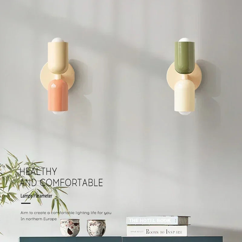 Macaron wall lamps mounted above a cabinet in a modern living space