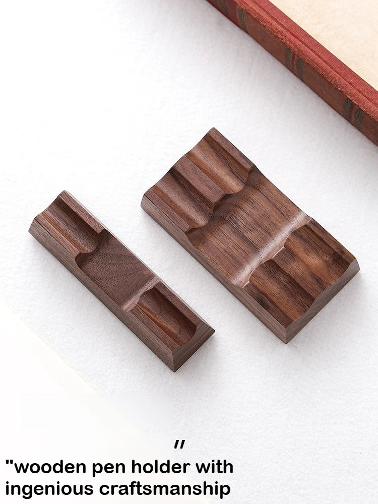Single and double walnut pen holder stands on a desk next to a book