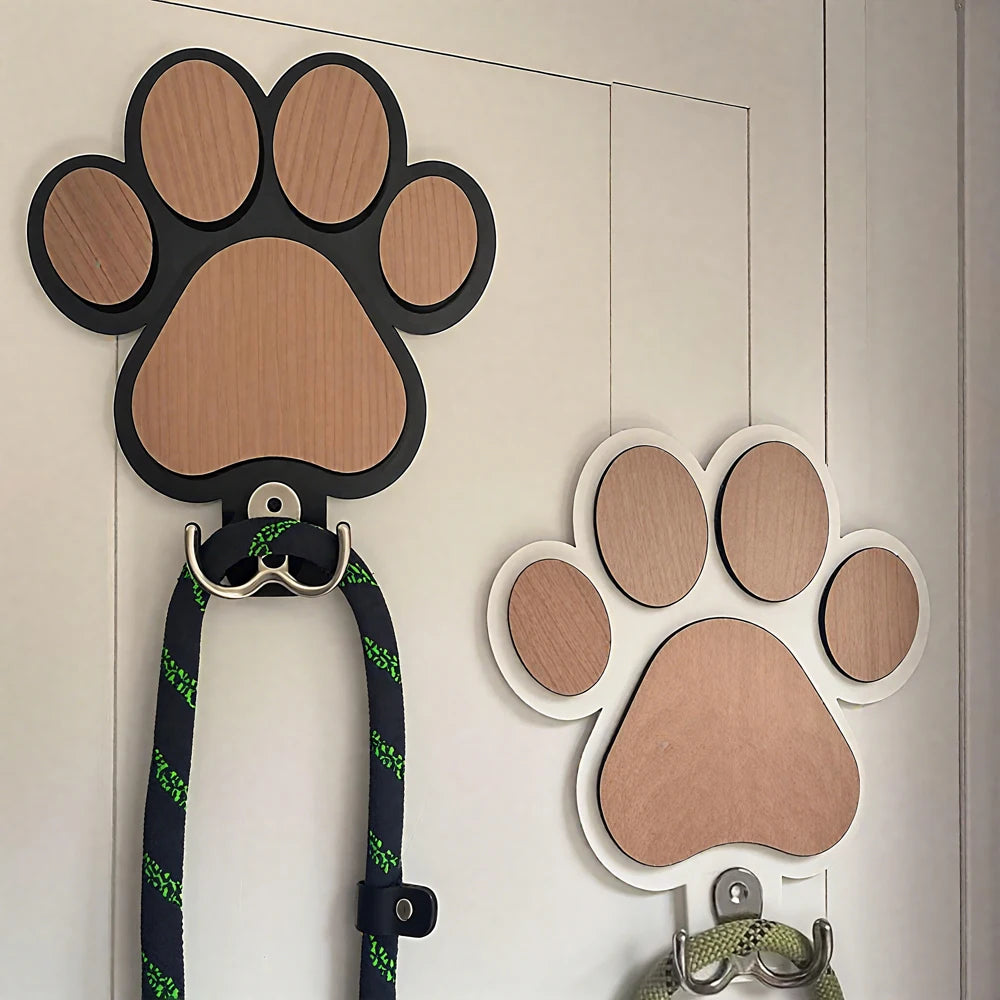 Pair of paw print wood wall hooks with leashes hanging, shown on a door or closet