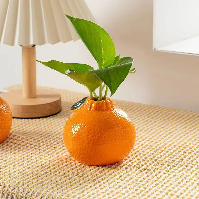 ceramic orange fruit vase on side table with lamp