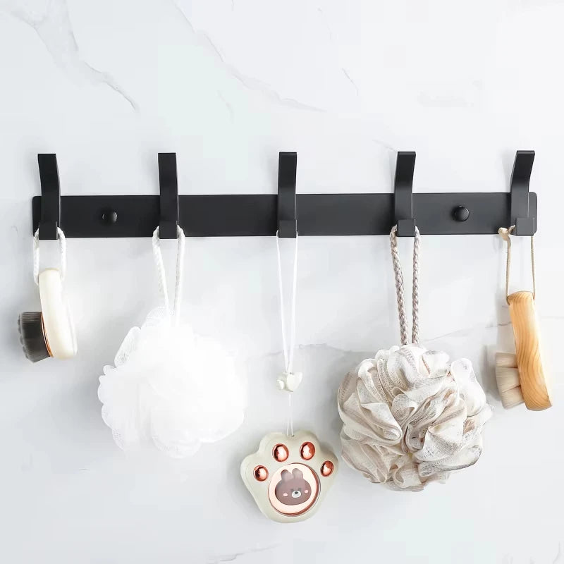 Front view of black wall-mounted hook rack with five hooks in use