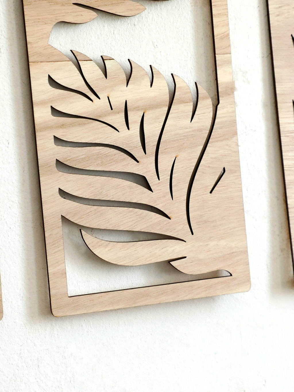 Detail of wood grain and leaf cutouts in rectangular wall art panel
