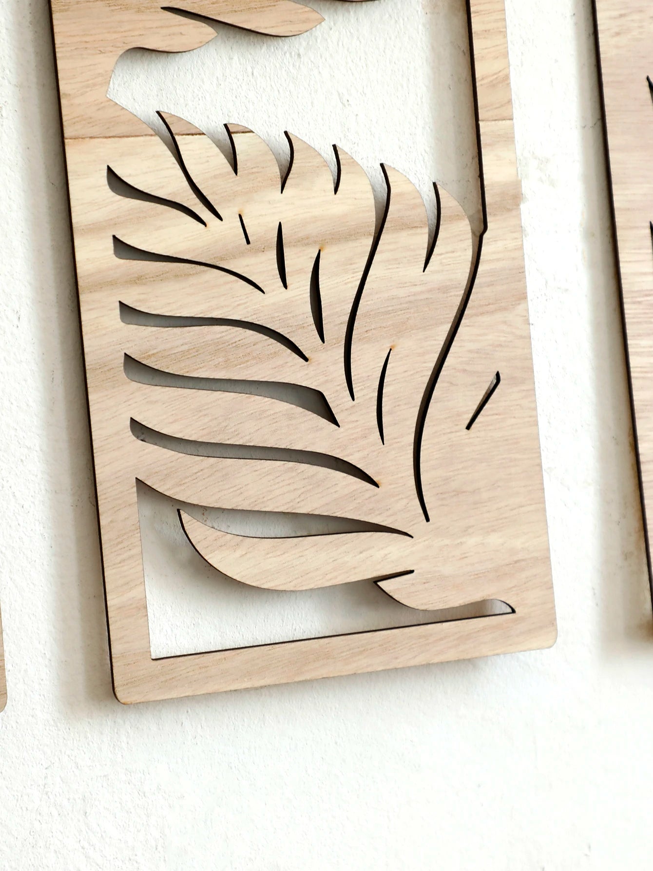 Detail of wood grain and leaf cutouts in rectangular wall art panel